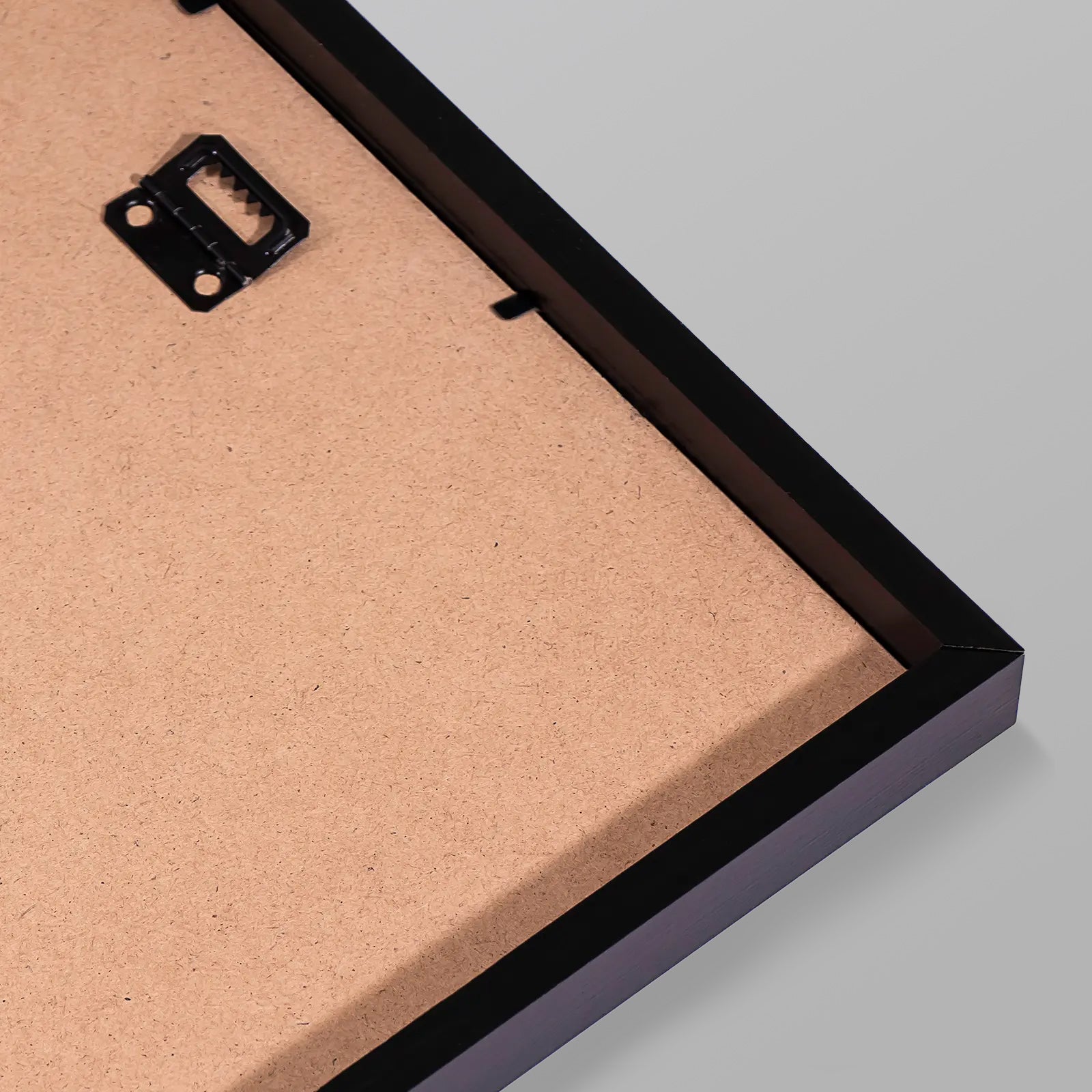 Close-up of a cardboard backing with a black frame on a gray background