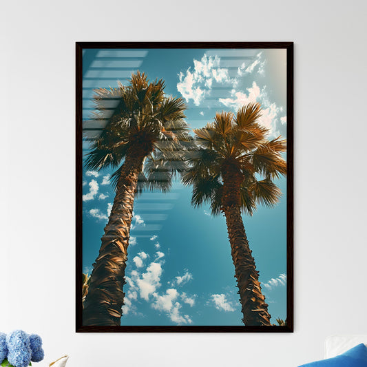 A Poster of two palm trees amidst a blue - A - Framed Art Print